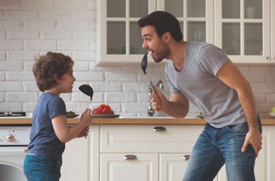 Papa und Sohn tanzend in der Küche