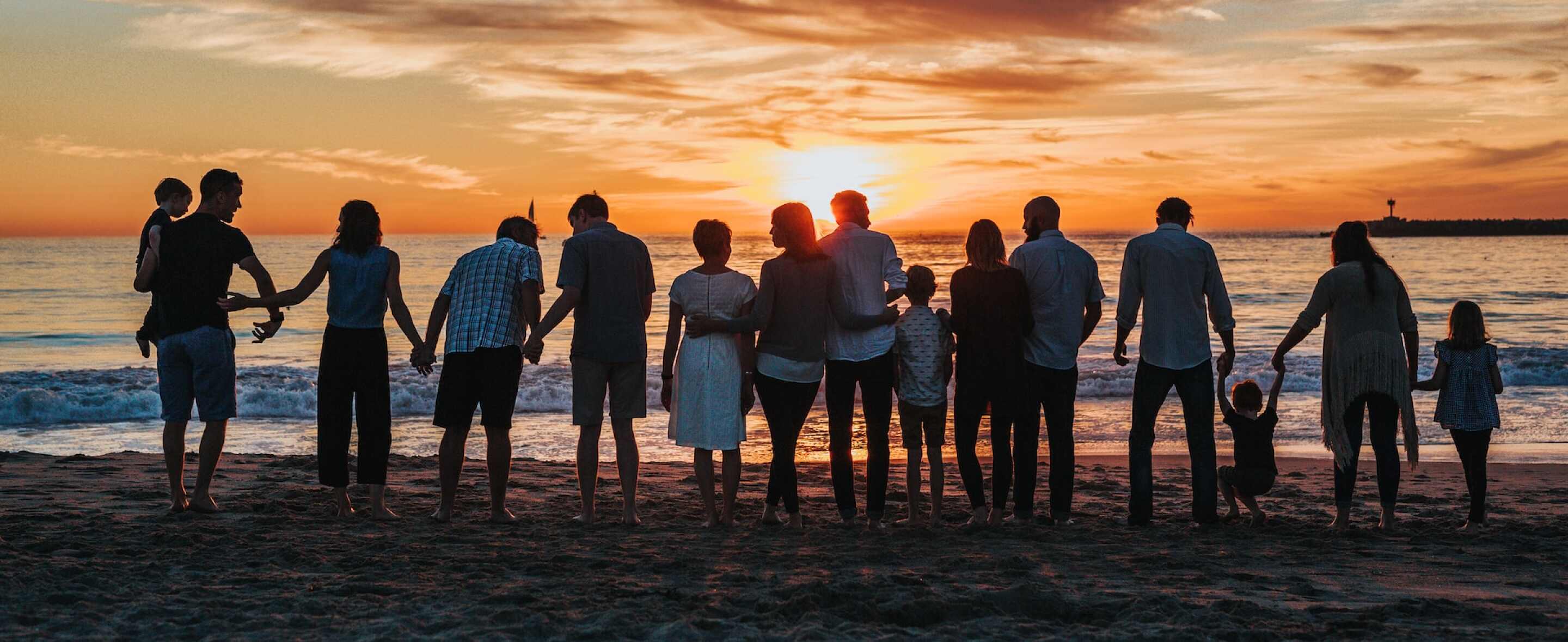 Viele Generationen schauen am Meer den Sonnenuntergang